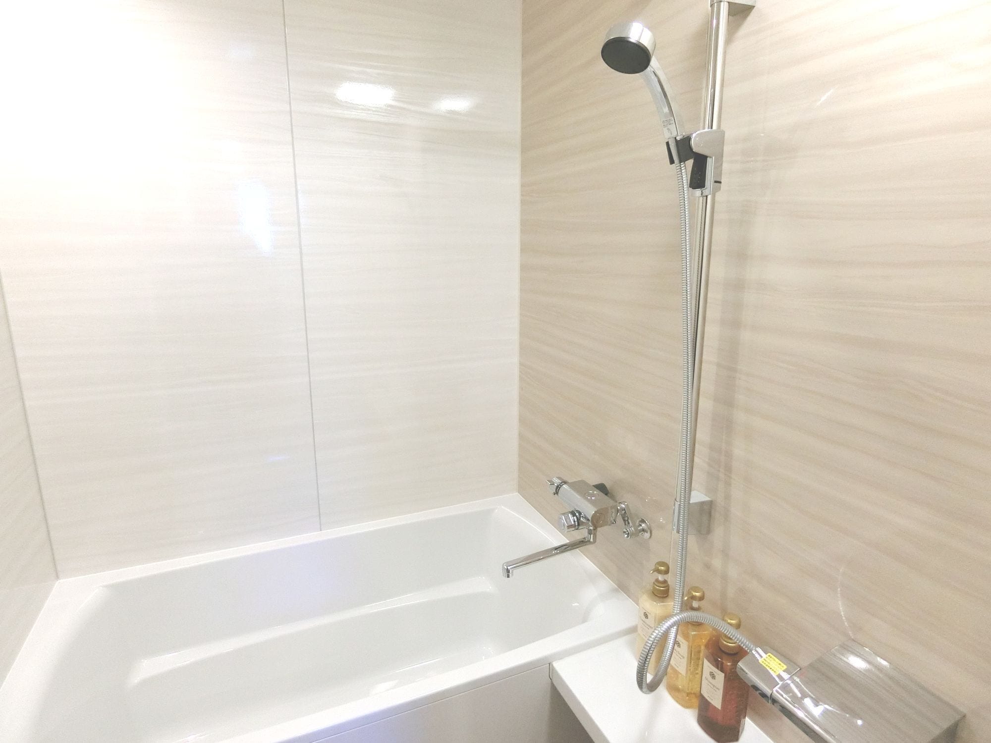 A modern bathroom with a bathtub, a showerhead, and a hand shower.