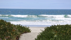 A beach with waves and a clear sky.