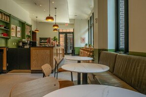 Interior d'una cafeteria amb barra, seients i una vista per la finestra.