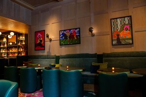 Een bar met zitplaatsen en kunst aan de muur.
