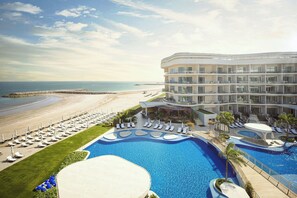 A resort with a large pool, beach access, and a multi-story building. - The St. Regis Al Mouj Muscat Resort (Muscat)