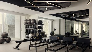 A modern gym with exercise equipment, large windows, and a minimalist design.