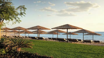 On the beach, white sand, sun loungers, beach umbrellas