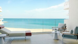 A balcony with a view of the sea, furnished with a sofa, chairs, and a small table. - The St. Regis Al Mouj Muscat Resort (Muscat)