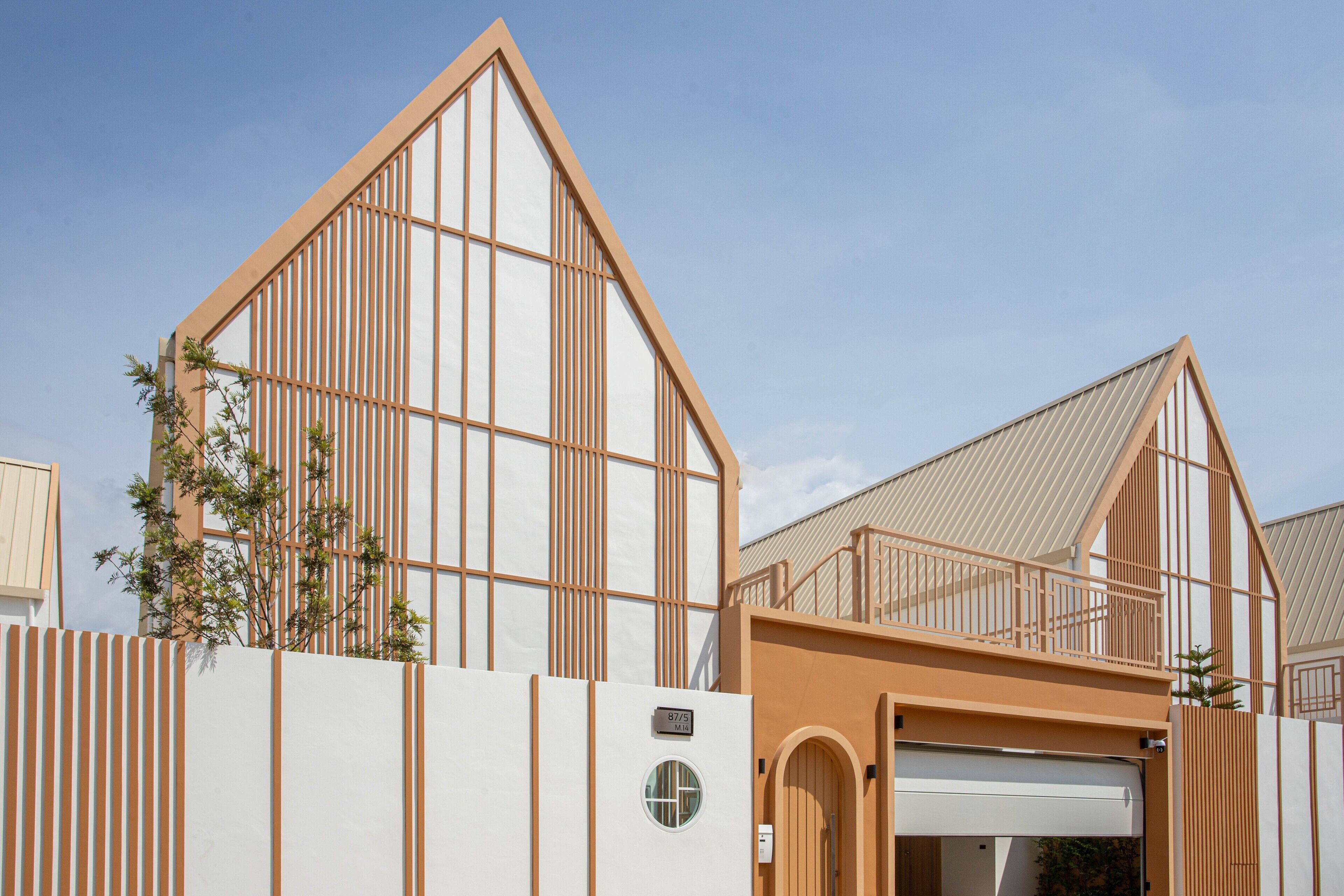 A modern building with a triangular roof and a garage door.