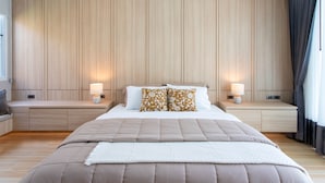 Un dormitorio moderno con una cama grande, dos lámparas de noche y un panel de pared de madera.