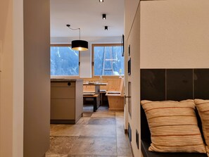 Relax in a serene space with a central seating area, large window, and comfortable bed.