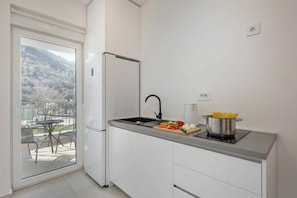 Uma cozinha moderna com fogão embutido, pia e geladeira.