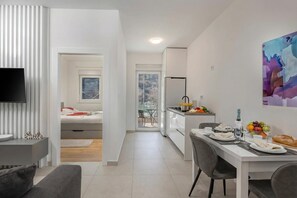 Eine moderne Wohnung mit Essbereich, Küchenzeile und einem an der Wand befestigten Fernseher.