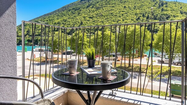 A balcony with a table, two cups, and a potted plant. - Sea-View Balcony Apt Lady Laura, Plomin, Croatia (Plomin)