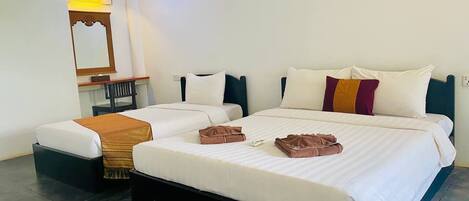 A hotel room with two beds, a mirror, a chair, and a wall-mounted air conditioner.