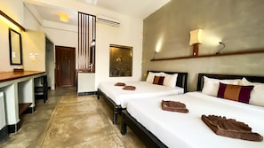 Habitació d'hotel amb dos llits, un escriptori i un mirall. Hi ha un aire condicionat fixat a la paret i un quadre gran sobre els llits.