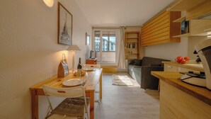 A compact living space with a dining area, kitchenette, and a view of the outside. - Cham Sud Genévrier104 sleeps 2 next Aiguille du Midi, Chamonix, France (Chamonix)