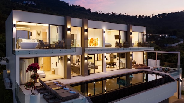 A modern multi-story house with a large glass pool, multiple bedrooms, and a dining area. - Luxury 5 Bedroom Modern Villa - KBR17 (Koh Samui)
