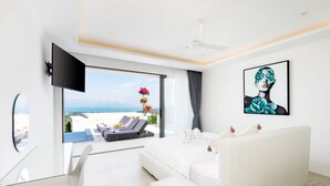 A modern hotel room with a large bed, a desk, and a view of the ocean. - Luxury 5 Bedroom Modern Villa - KBR17 (Koh Samui)