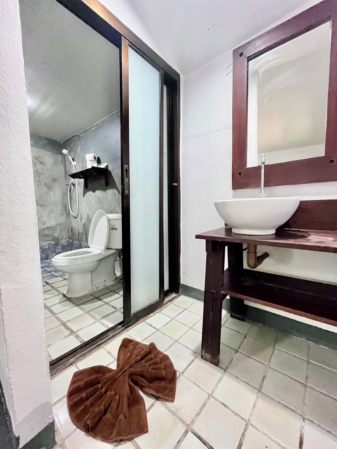 A bathroom with a toilet, shower, and sink.