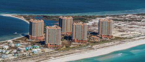 A coastal hotel complex with multiple high-rise buildings, beachfront access, and a sandy beach.