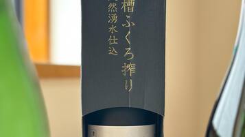 A bottle of sake with a medal on top, placed in a black box.