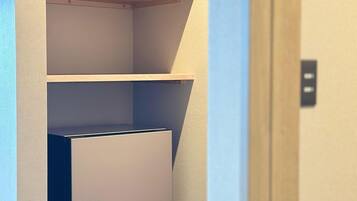 A narrow hallway with a built-in shelving unit and a door at the end.