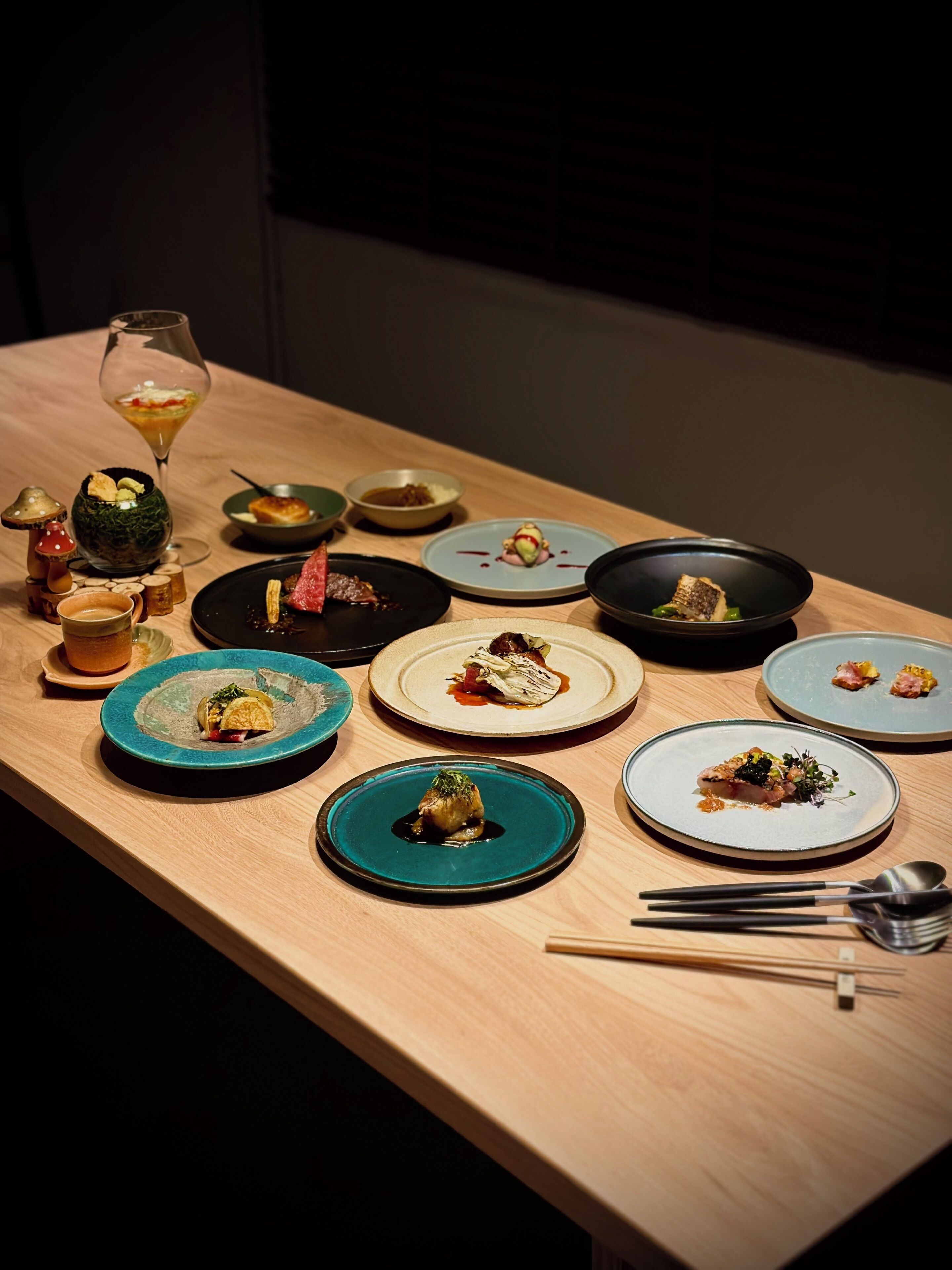 A table with various dishes and a wine glass, suggesting a dining setting.