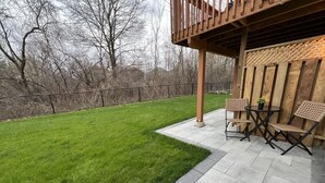 A patio with a wooden deck, a small round table, two chairs, and a potted plant. - Bright 2BR unit | Free Parking | Family Friendly | Richmond Hill (Richmond Hill)