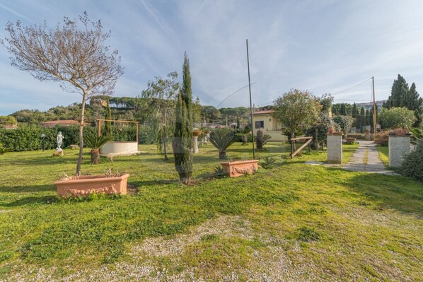 Un jardín bien cuidado con diversas plantas y una estatua.
