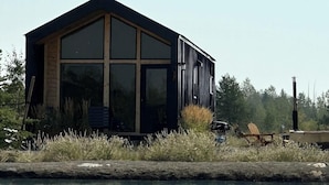 Et moderne hus med store vinduer og et spejlbillede i vandet.