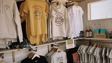 A clothing store with various t-shirts and hoodies, including some with 'Yellowstone Peaks Hotel' branding.
