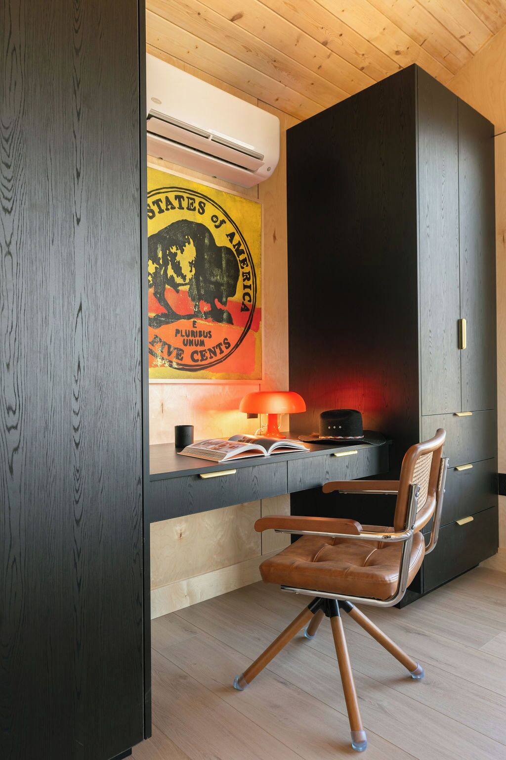 A modern office space with a desk, chair, and a poster on the wall.