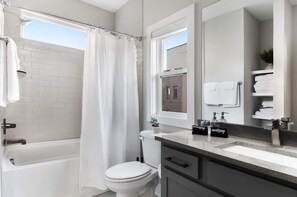 A modern bathroom with a bathtub, toilet, and sink.
