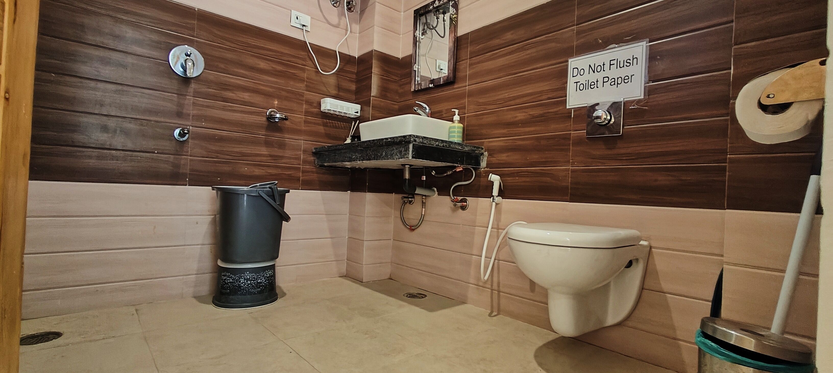 A bathroom with a toilet, sink, and a trash bin.