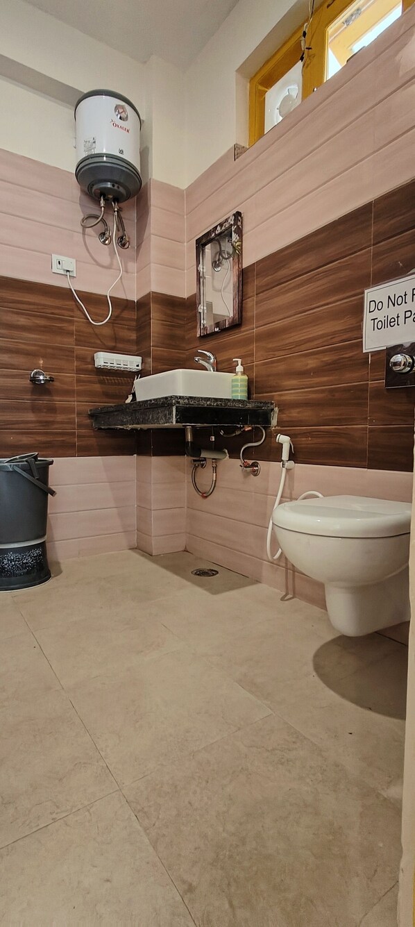 Un baño con inodoro, lavamanos y ducha. Hay un cartel en la pared que dice 'No usar inodoro'.