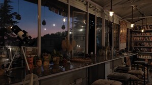 A bar area with a telescope, shelves with books, and various decorative items.