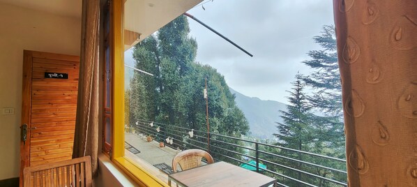 A balcony with a wooden door labeled "Room 3" and a view of a mountainous landscape. - The Unmad (Dharamshala)