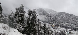 A snowy mountainous landscape with a village in the valley. - The Unmad (Dharamshala)