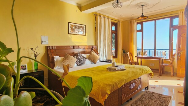 A bedroom with a large bed, a balcony, and a view of the sea.