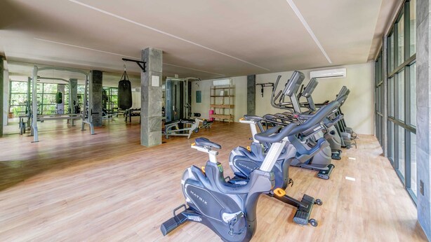 A gym with cardio machines, weightlifting equipment, and a large mirror. - Aldea Zama Villa with Private Pool, Art & Spa (Tulum)