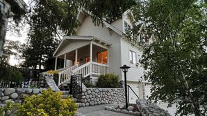 Una casa de dos pisos con un camino de piedra que lleva a un porche.