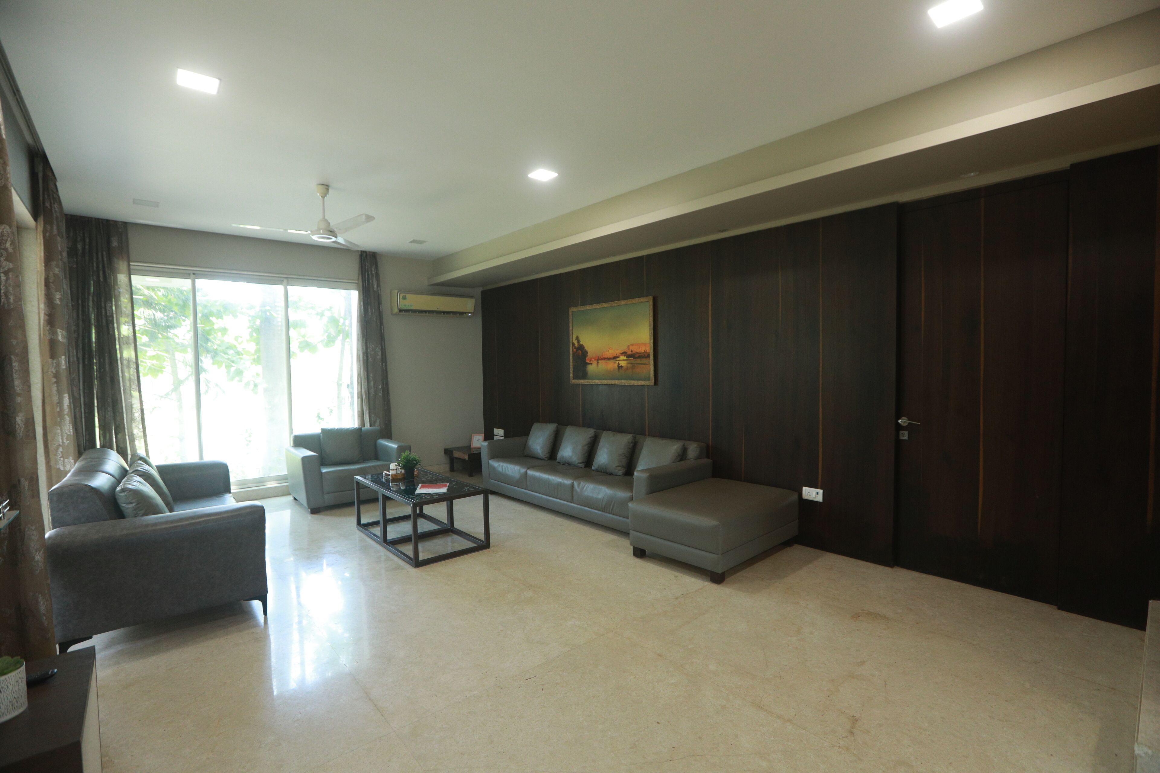 Un salón moderno con un sofá gris, una mesa de centro y un cuadro en la pared.