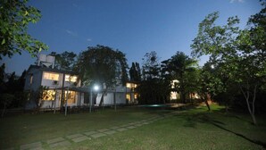 Una casa moderna de dos pisos con un césped cuidado y una piscina.