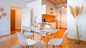 A modern kitchen with white cabinets, a wooden countertop, and a hanging light fixture.