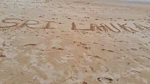 Une plage où l’on voit des empreintes de pas et les mots « Ski Loma » écrits dans le sable.