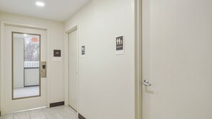 A hallway with a door marked 'EXIT' and a 'RESTROOM' sign. - MainStay Suites Chambersburg (Chambersburg)
