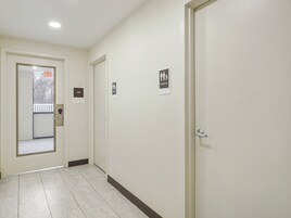 Un pasillo con una puerta señalizada con 'EXIT' y un letrero que indica 'RESTROOM'.