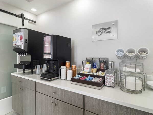 A coffee station with a branded dispenser, paper cups, and a sign for 'Dream Cup.' - MainStay Suites Chambersburg (Chambersburg)
