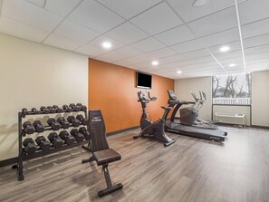 A gym with a bench, dumbbells, an elliptical, and a treadmill. - MainStay Suites Chambersburg (Chambersburg)