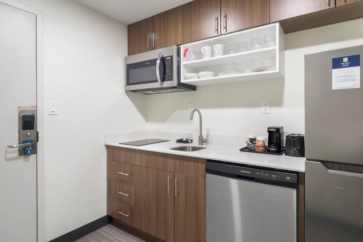Una cocina compacta equipada con microondas, cafetera, tostadora y lavavajillas.