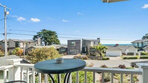 A residential area with houses, a modern building, and a clear blue sky. - Opal Cliff Overlook (Santa Cruz)