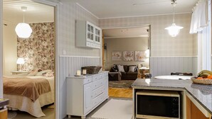 Un dormitorio moderno y bien iluminado con una cama, cómoda y televisor.