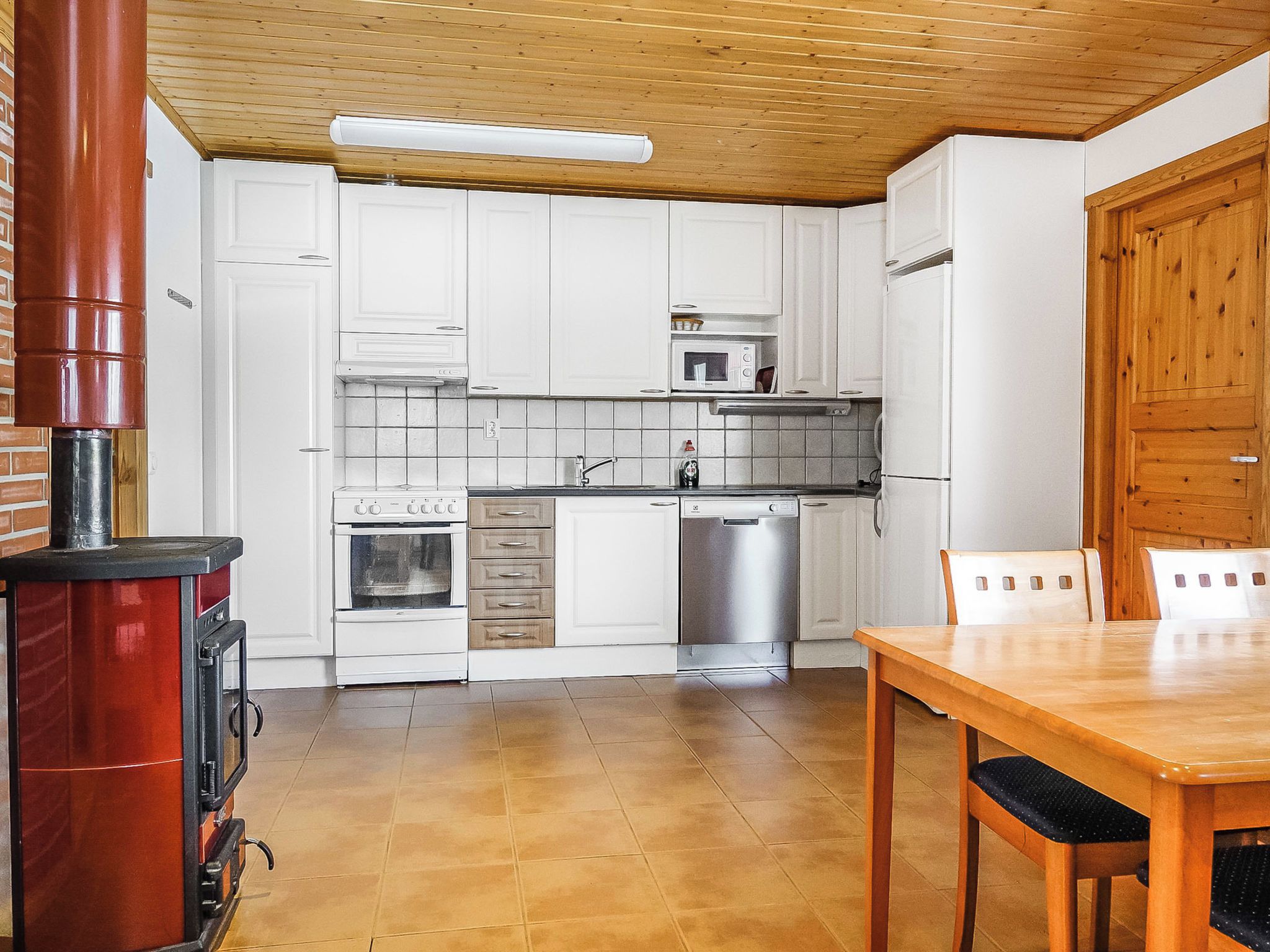 A kitchen with white cabinets, a stove, a microwave, and a dishwasher.
